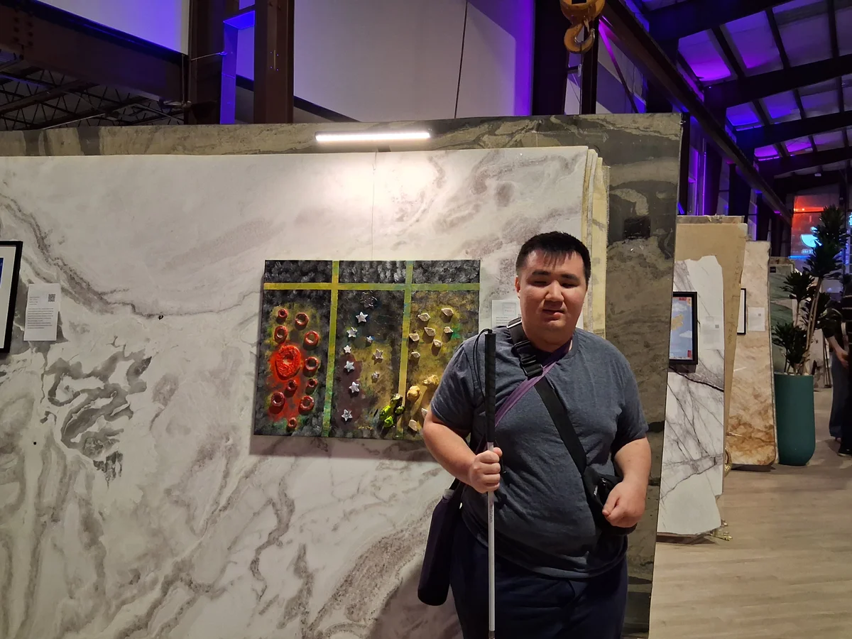 Mixed media artwork featuring three vertical panels with textured surfaces in charcoal, red, white, and gold tones, separated by yellow-green dividers, mounted on white marble with gray veining.